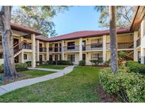 Inviting condo complex with lush landscaping, terracotta roof, and a neatly paved walkway at 1712 Hammock Pine Blvd # 1712, Clearwater, FL 33761