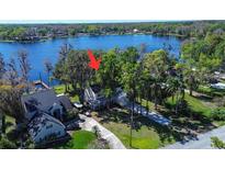 Stunning lakefront property with lush greenery and a charming two-story home nestled among the trees at 18715 Lakeshore Dr, Lutz, FL 33549