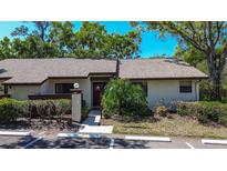 Charming front exterior of condo features a guest parking spot, inviting entrance, and lush landscaping at 4031 Bluff Oak Ct, Palm Harbor, FL 34684