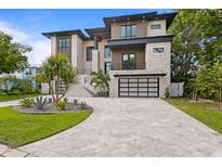 Modern home with a statement driveway, a two car garage, and manicured landscaping creating great curb appeal at 48 Sandpiper Rd, Tampa, FL 33609