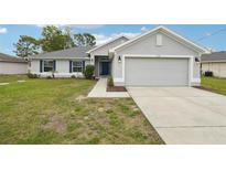 Charming home featuring a large garage, well-kept lawn, and freshly painted exterior at 5134 Jenson Ave, Spring Hill, FL 34608