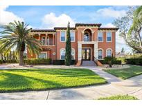 Stunning two-story home features a terracotta facade, lush landscaping, and a grand entrance at 5910 La Rosa Ln, Apollo Beach, FL 33572