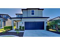 Two-story home featuring a two-car garage, modern landscaping and craftsman style pillars at the entry at 8563 Starlight Loop, Parrish, FL 34219