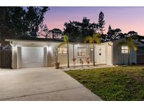 Charming single-story home featuring a well-maintained lawn, attached garage, and lovely landscaping at 9016 Bay Ne St, St Petersburg, FL 33702