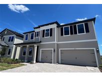 Beautiful two-story home featuring a two-car garage, gray exterior, and a well-maintained front yard at 2595 Wise River Ln, Zephyrhills, FL 33541