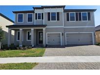 Charming two-story home featuring a two-car garage, manicured lawn, and classic architectural details at 2595 Wise River Ln, Zephyrhills, FL 33541