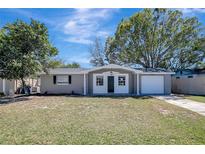 Charming single-Gathering home features a well-manicured lawn and attached one car garage at 3108 Palamore Dr, Holiday, FL 34691