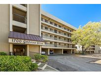 Condominium exterior showing covered parking, balconies, and the address 1700 Golfview Drive on a sunny day at 1728 Golfview Dr # 1728, Tarpon Springs, FL 34689