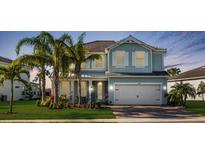Charming two-story home with a two-car garage, lush lawn and decorative palm trees at 3248 Anchor Bay Trl, Bradenton, FL 34211