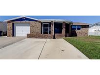 Charming single-story home with a brick exterior, attached garage, and well-maintained lawn at 3805 Baden Dr, Holiday, FL 34691