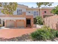 Inviting townhome with brick accents, a two-car garage, and lush landscaping at 711 S Oregon Ave, Tampa, FL 33606