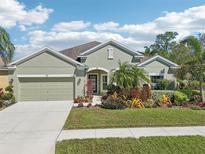Charming single-story home featuring a well-manicured lawn, beautiful landscaping, and an attached two-car garage at 1503 Yale Castle Ct, Ruskin, FL 33570