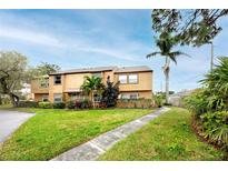 Inviting two-story home with lush lawn, mature trees, and well-maintained landscaping on a sunny corner lot at 1824 Clearbrooke Dr, Clearwater, FL 33760