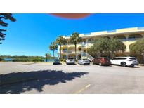 Inviting exterior view of a multi-story building with palm trees and ample parking at 2222 Norwegian Dr # 24, Clearwater, FL 33763