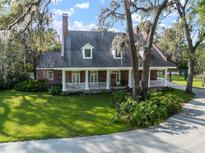 Charming brick home featuring a welcoming front porch, lush lawn, and mature trees at 2906 Pemberton Creek Dr, Seffner, FL 33584