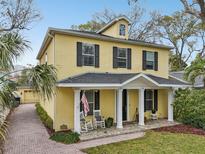 Charming yellow two-story home with a welcoming front porch and manicured landscaping at 2915 W Bay View Ave, Tampa, FL 33611