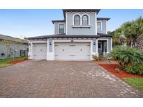 Beautiful two-story home boasts a paver driveway and a three-car garage at 4575 Tivoli Dr, Wesley Chapel, FL 33543