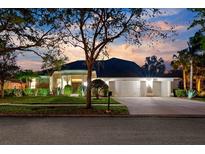 Beautiful single-story home featuring a three-car garage, well-manicured lawn, and lush landscaping in a tranquil neighborhood at 5703 Tanagerside Rd, Lithia, FL 33547