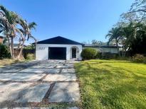 Charming single-story home with a modern black garage door and minimalist landscaping at 623 Cordova Ne Blvd, St Petersburg, FL 33704