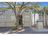 Inviting condo exterior with mature trees, attached garage, and well-maintained landscaping at 732 Coral Reef Dr # 732, Tampa, FL 33602