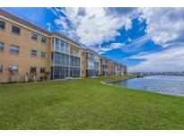 Beautiful waterfront condo building with well-maintained green lawn and tropical landscaping at 1 Boca Ciega Point Blvd # 211, St Petersburg, FL 33708