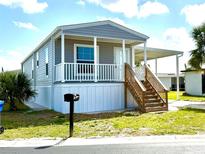 Charming single-story home with covered porch, carport, and well-maintained landscaping at 105 W Saint Johns Way, Apollo Beach, FL 33572