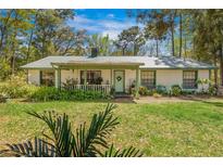 Charming single-story home with a covered front porch and well-maintained landscaping at 20354 Gamble Dr, Brooksville, FL 34601