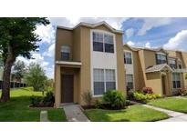 Inviting two-story townhouse featuring a well-maintained lawn and classic architectural details at 6002 Osprey Lake Cir, Riverview, FL 33578