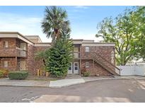 Two-story brick building with palm trees, exterior stairs, and sidewalk at 10423 Carrollbrook Cir # 102, Tampa, FL 33618