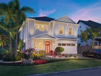 Charming two-story home with a red front door, attached garage, beautiful landscaping, and tropical palm trees at 1819 Maryland Ne Ave, St Petersburg, FL 33703