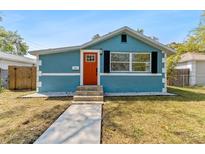 Charming blue bungalow with a bright orange front door and manicured landscaping at 1941 48Th S St, St Petersburg, FL 33711