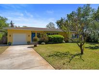 Charming yellow single-story home with a well-maintained front yard and blue door at 419 Richards Ave, Clearwater, FL 33755