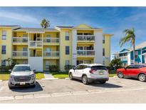 Inviting three-story condo building featuring balconies, palm trees, and convenient parking spaces for residents and guests at 455 Alt 19 S # 162, Palm Harbor, FL 34683