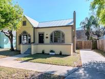 Charming single-story home with a metal roof, arched windows, and a well-maintained front yard at 5807 N Miami Pl, Tampa, FL 33604