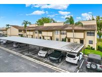 Exterior view of carport parking and a well-maintained tan apartment complex under a sunny sky at 9209 Seminole Blvd # 145, Seminole, FL 33772