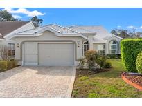 Charming home featuring a well-manicured lawn and a lovely brick driveway and walkway to the front door at 9339 Creole Ct, Weeki Wachee, FL 34613