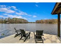 Relaxing view from the dock with three chairs overlooking the tranquil water and lush treeline at 10101 Tarpon Springs Rd, Odessa, FL 33556