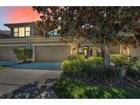 Lovely townhome with a two-car garage, pretty landscaping, and a welcoming front entrance at 13207 San Blas Loop, Largo, FL 33774