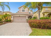 Charming two-story home with a brick driveway, lush landscaping, and a two-car garage at 16011 Bella Woods Dr, Tampa, FL 33647
