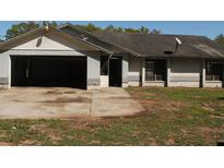 View of a single-story home with an attached, open garage and a front door at 41305 Dykas Ln, Dade City, FL 33525