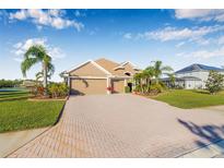 Charming single-story home featuring a three-car garage, brick driveway, and lush tropical landscaping at 4315 70Th E Ave, Ellenton, FL 34222