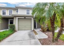Charming townhome showcasing a single-car garage, well-kept lawn, and a welcoming entryway at 5831 Leopardstown Dr, Tampa, FL 33610