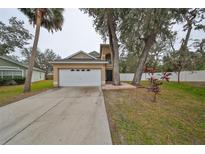 Charming home featuring an attached two-car garage, mature trees and well maintained landscaping at 6930 Summer Harbor Ln, Riverview, FL 33578