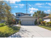 Two-story home featuring a spacious driveway, two-car garage, and landscaping at 8890 Arabella Ln, Seminole, FL 33777