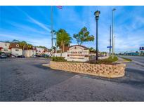 Tudor Cay Condominiums sign in a waterfront community with palm trees, manicured landscaping and blue skies at 9115 Tudor Dr # E109, Tampa, FL 33615