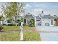 Charming single-story home featuring lush tropical landscaping and a welcoming front porch at 1016 Greenleaf Way, Tarpon Springs, FL 34689