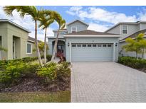Charming home featuring a two-car garage, well-manicured landscaping, and an inviting front entrance at 319 Shore Crab Way, Apollo Beach, FL 33572