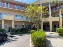 View of building exterior with covered parking, landscaping, and handicap parking sign on a clear day at 2022 Camelot Dr # 9, Clearwater, FL 33763