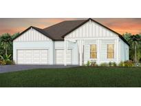 Charming home features a two-car garage, covered porch, and manicured lawn at 37368 Gunnison Dr, Zephyrhills, FL 33540