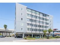 View of Suncoast Towers featuring a light blue exterior, well-kept landscaping, and covered parking at 841 4Th N Ave # 57, St Petersburg, FL 33701